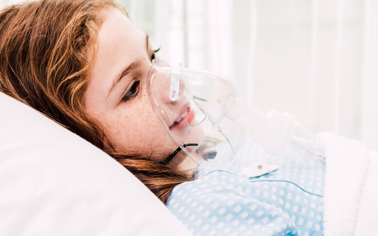 Meisje met masker ligt in bed