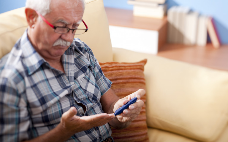 Personne agée diabétique utilisant un glucomètre sanguin