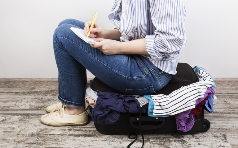 Check list reis vrouw zit op koffer