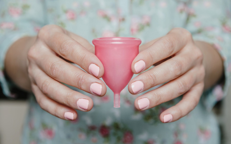 Vrouw houdt menstruatiecup in haar handen