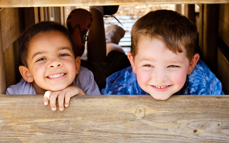 Twee glimlachende jongens in een speeltuin