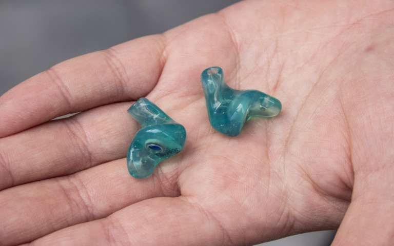 op maat gemaakte oordoppen liggen in een hand