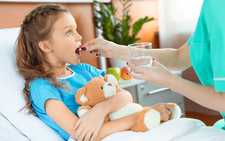 Fille malade à l'hôpital qui reçoit un médicament de l'infirmière