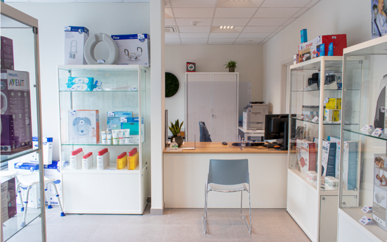 LM Plus kantoor en Zorgboetiekpunt Menen met loket en etalagekasten met hulpmiddelen in uitgestald.