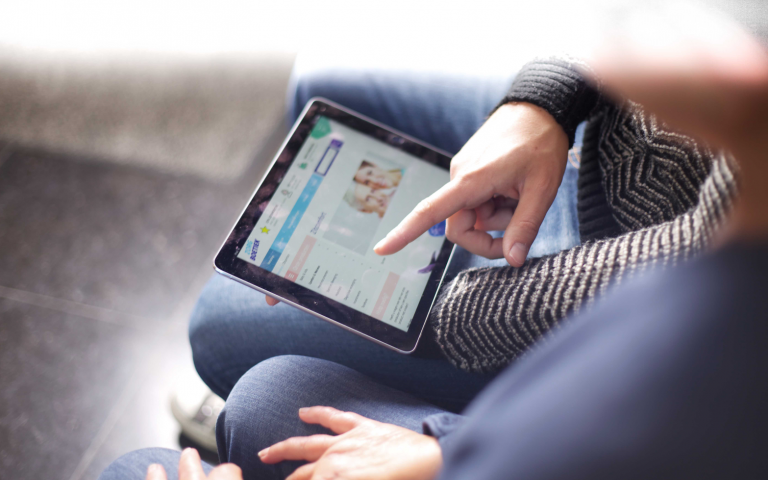 Iemand surft op de webshop van Zorgboetiek op een tablet.