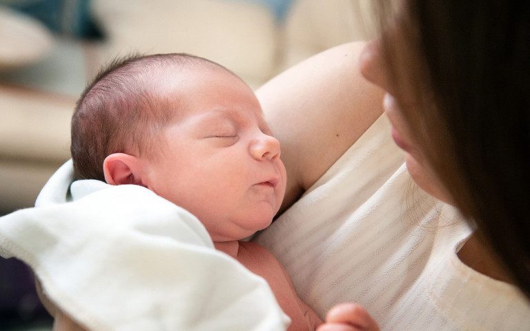 bébé dormant dans les bras de maman