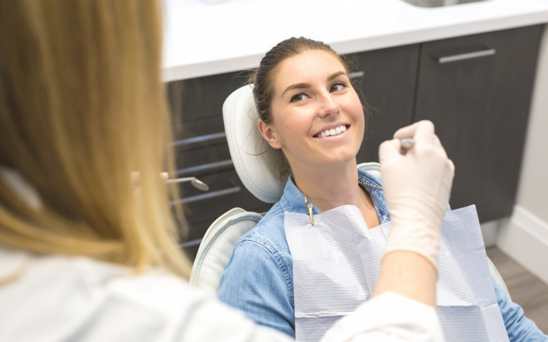 une femme allongée dans un fauteil dentaire pour vérifier ses dents