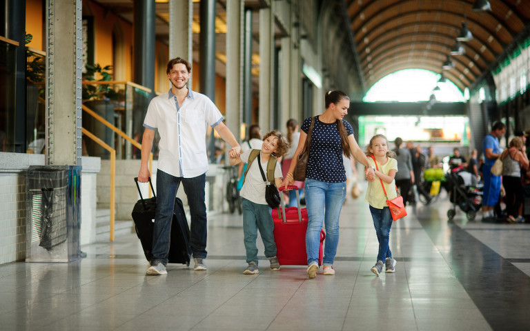 famille dans une gare prête à partir en vacances