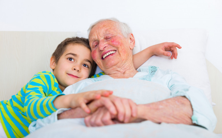 gelukkige oude dame in bed met kleinzoon