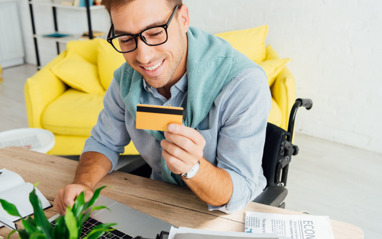 jonge man in rolstoel doet online aankoop