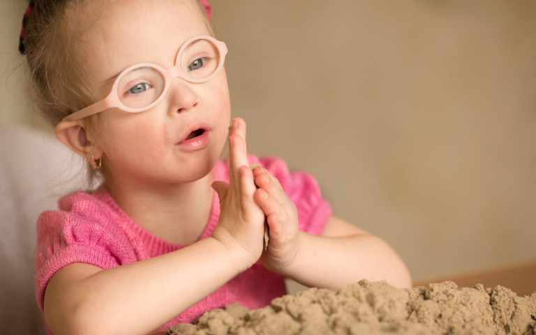 kindje met beperking speelt met zand 1