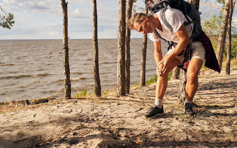 homme avec une blessure au genou en voyage