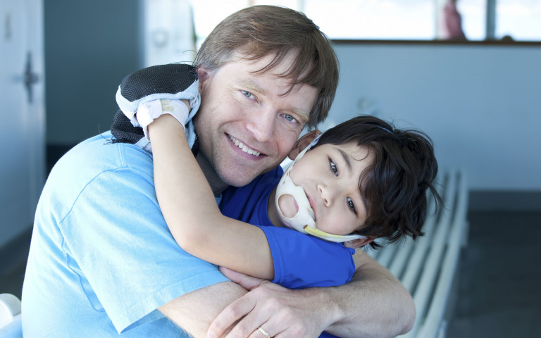 papa embrasse son petit fils handicapé