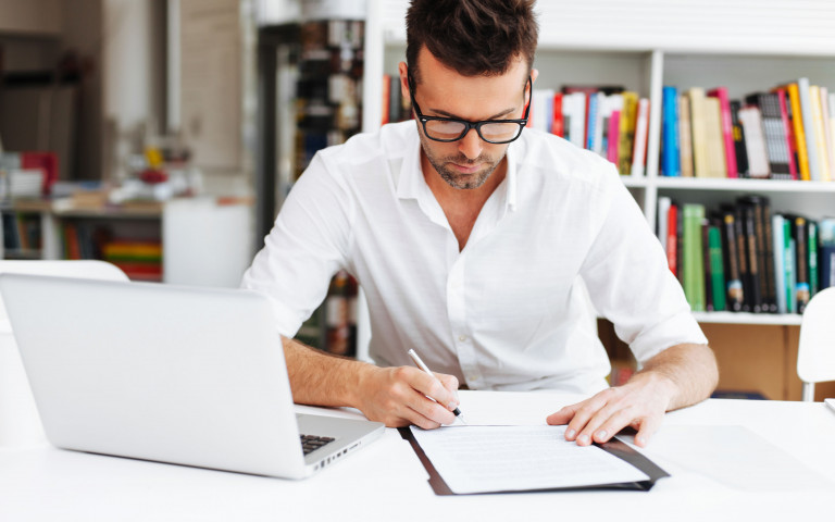 homme à son bureau qui signe des contrats