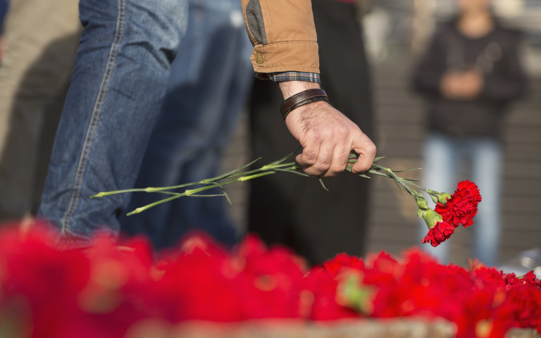 Man legt bloemen neer bij overlijden