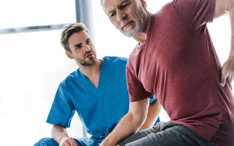 Man met rugpijn bij kine