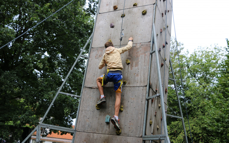 Kind klauwert op klimmuur tijdens jongerenkamp zomervakantie