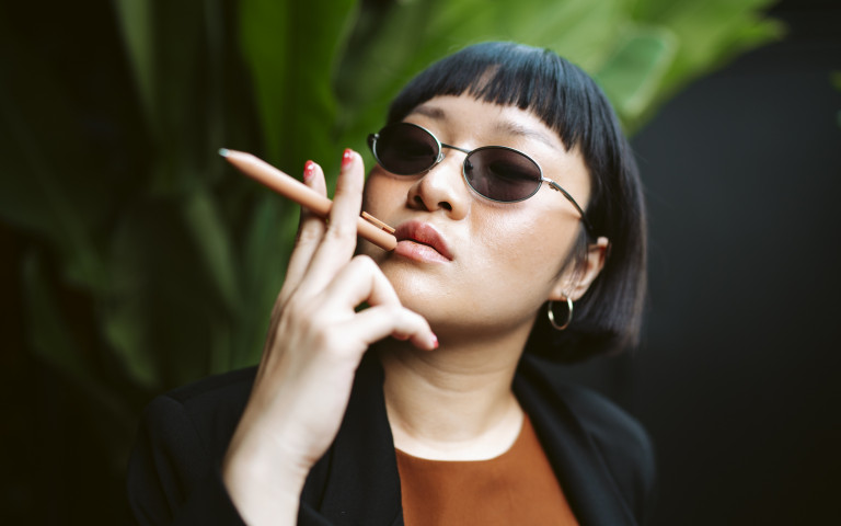 aziatische vrouw houdt pen vast als sigaret