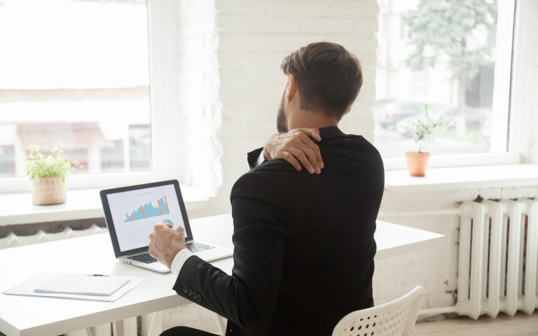 homme derrière un portable a une douleur à l'épaule