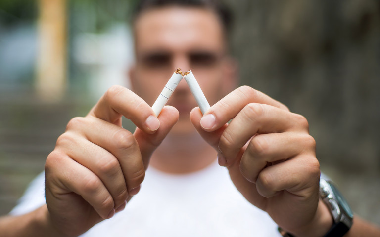 homme casse sa cigarette en deux