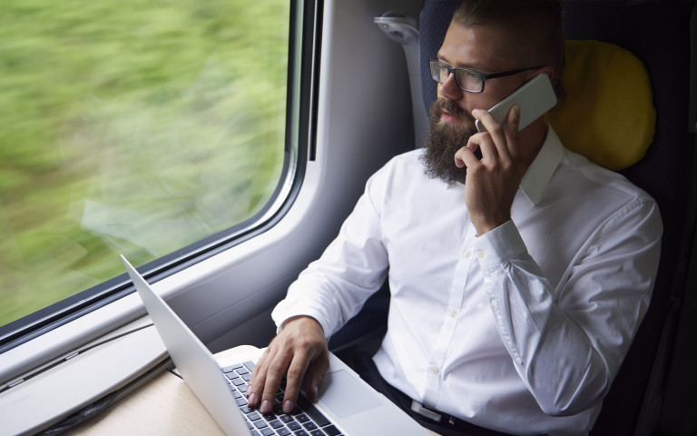 man in trein met laptop