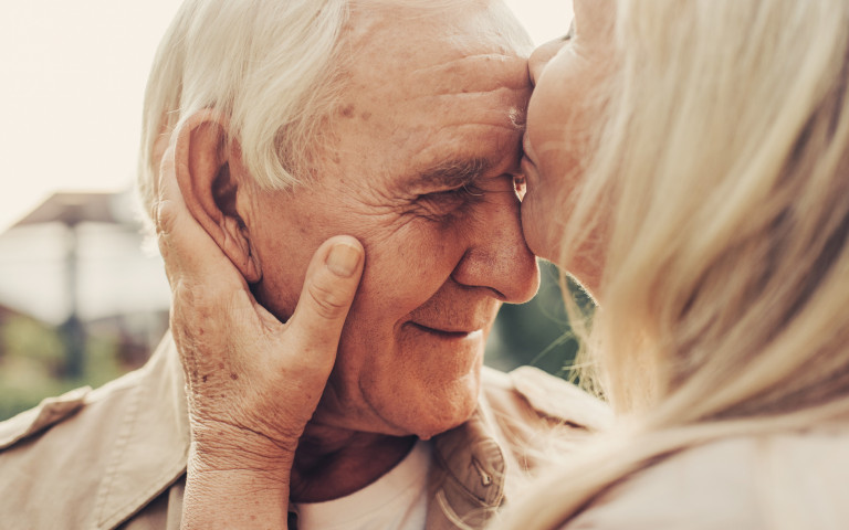 oude dame kust man op voorhoofd