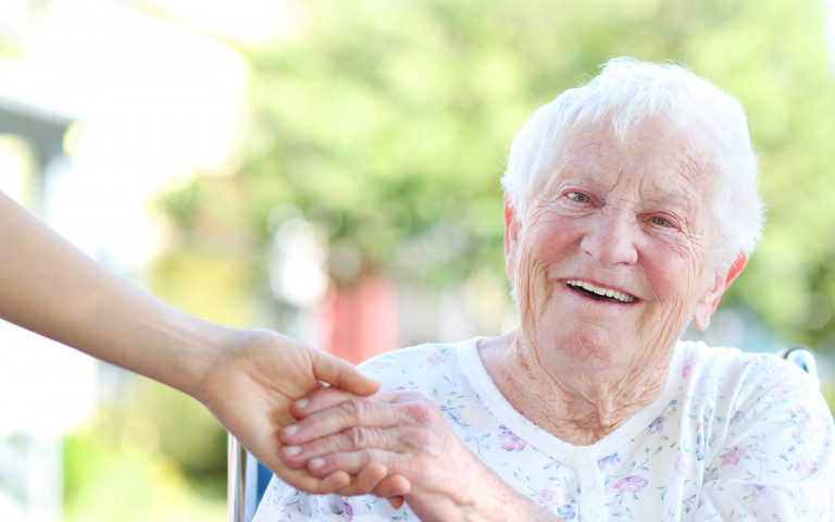 oude vrouw in rolstoel krijgt hulp