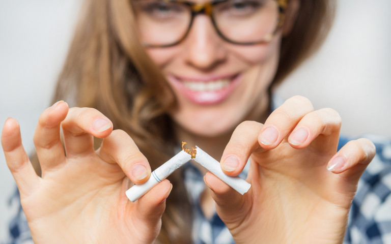 femme casse la cigarette en deux