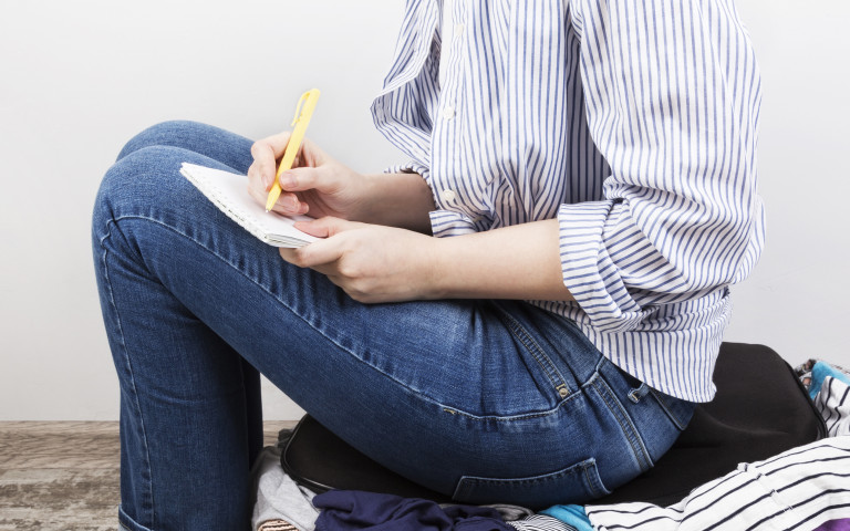 Femme avec checklist sur valise banner