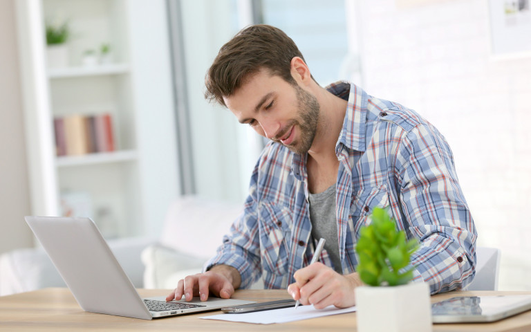un homme travaille à son bureau à domicile avec un ordinateur portable