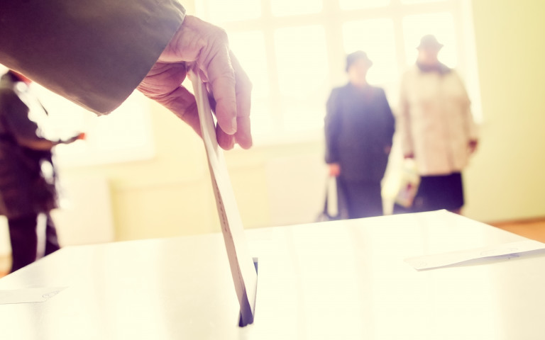 Kiezer deponeert brief in verkiezingsbus