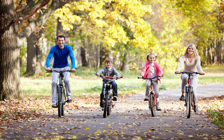Famille qui fait du vélo dans un décor automnal