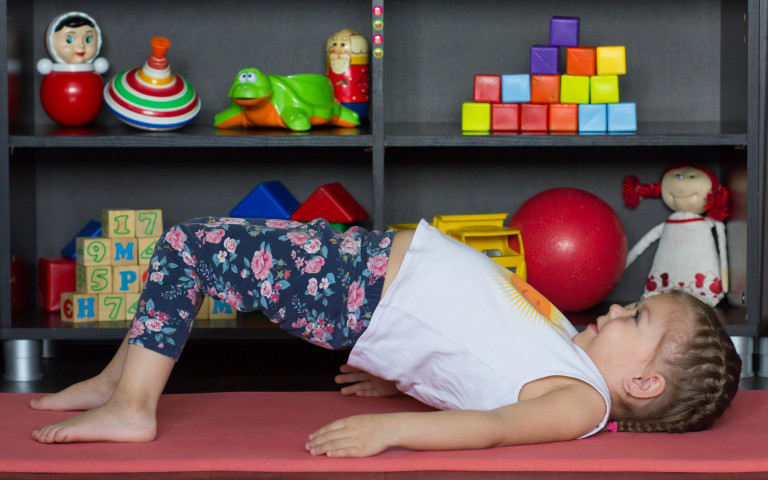 Kleuter doet yoga in de kleuterklas