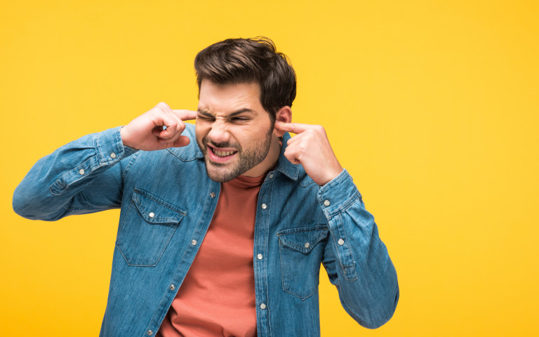 Man met vingers in zijn oren