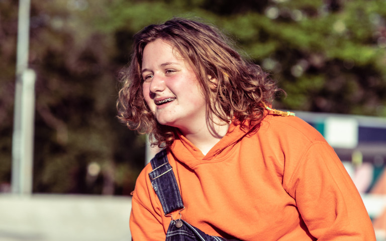 Tiener met beugel op skatebaan