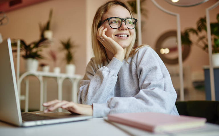 Student studeert aan bureau en lacht Generation LM
