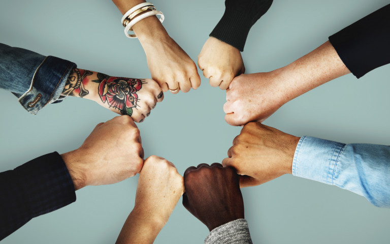 Meerdere personen geven elkaar een vuistje