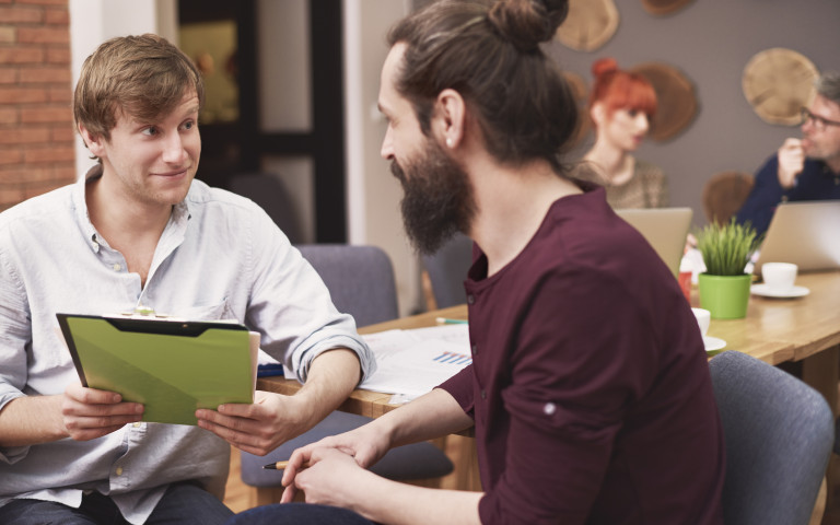 Man toont een map aan een andere man