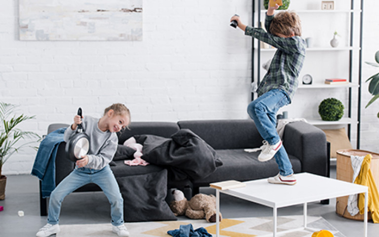 Twee jonge kinderen maken plezier in de zetel voor televisie