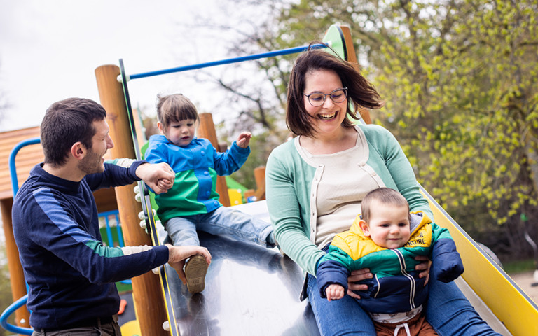 familie met jonge kinderen in de speeltuin