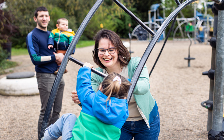Mama speelt met kind op klimrek
