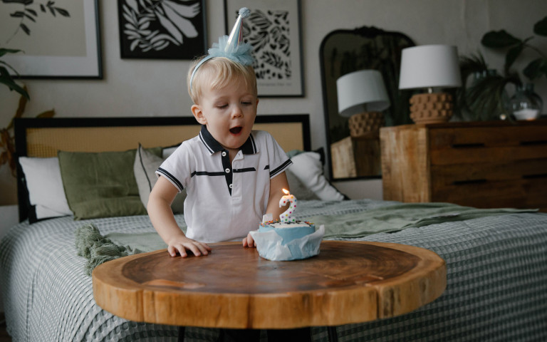 Peuter viert tweede verjaardag en blaast kaarsje uit