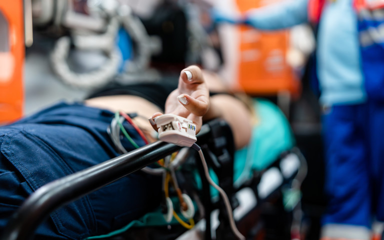 Persoon maakt gebruik van liggend vervoer, ligt aan zuurstofmeter