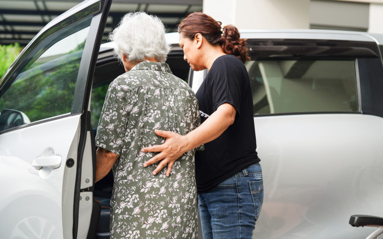 Oudere mevrouw krijgt begeleiding in auto