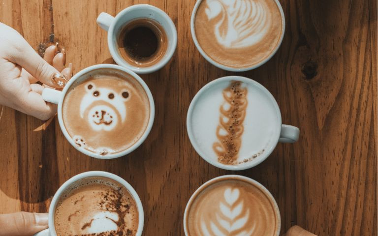 Cafés et main, fond bois