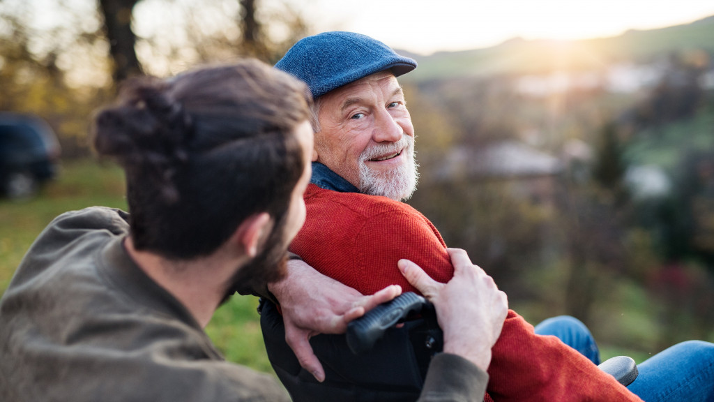 Oude man met pet in rolstoel