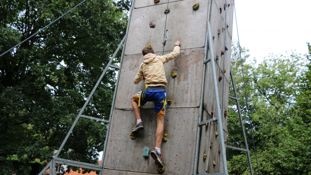 Kind klauwert op klimmuur tijdens jongerenkamp zomervakantie