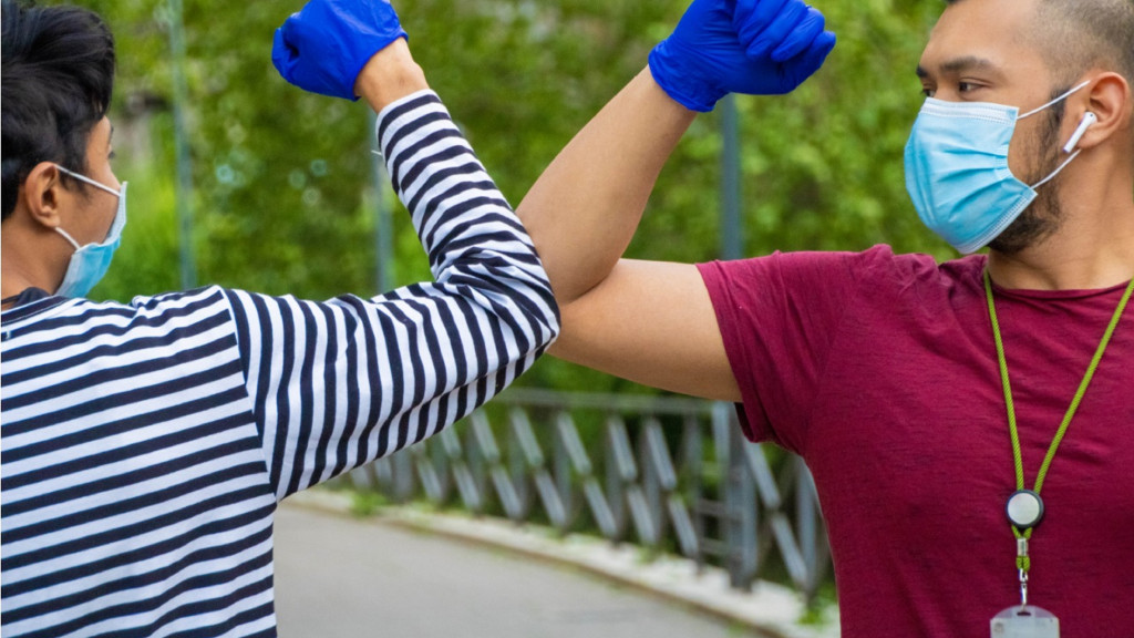 deux hommes se disent bonjour avec le coude en période de coronavirus