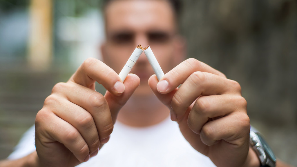 homme casse sa cigarette en deux