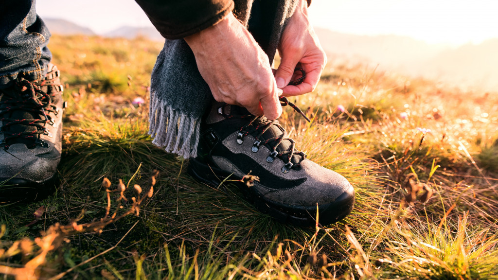 Homme fait ses lacets de chaussures de marche